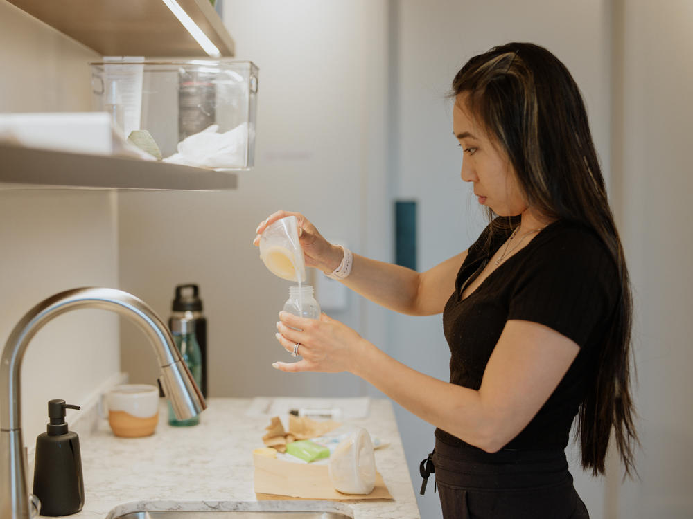 Tiffany Yu pours her breast milk into a bottle after pumping.