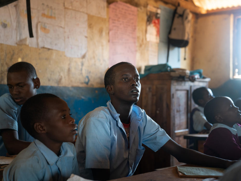 Paris Lekuuk, 15, (center) listens to a math lesson in the third-grade classroom of his primary school in northern Kenya.
