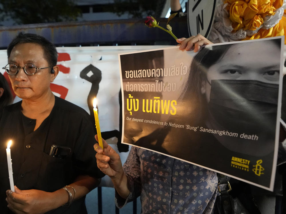 Thai activists hold a portrait of Netiporn Sanesangkhom, a member of the activist group Thaluwang outside of Criminal court in Bangkok, Thailand, on Tuesday.