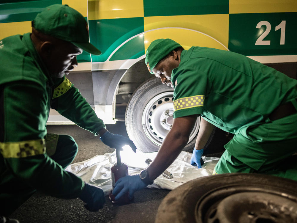 Paramedics Papinki Lebelo and Zuko Faltein change a burst tire at the Gugulethu clinic in Cape Town.