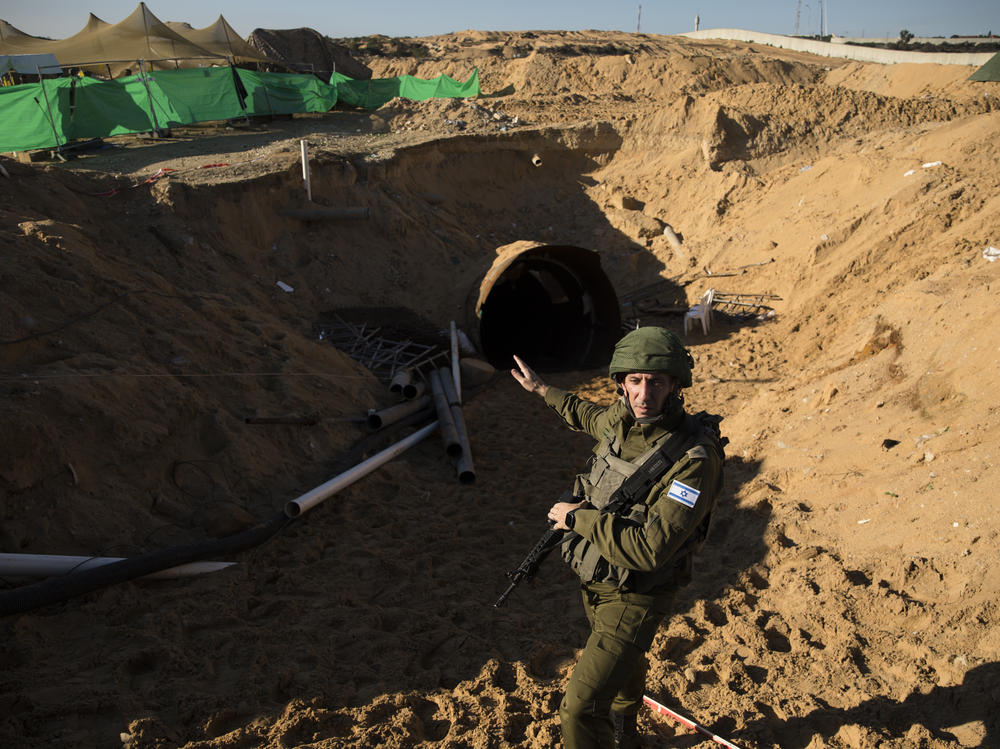 Israeli military spokesman Rear Adm. Daniel Hagari stands at the opening to a tunnel near the border with Israel on Dec. 15, 2023, northern Gaza Strip. The Israeli military said this was the largest tunnel they'd found yet in Gaza.