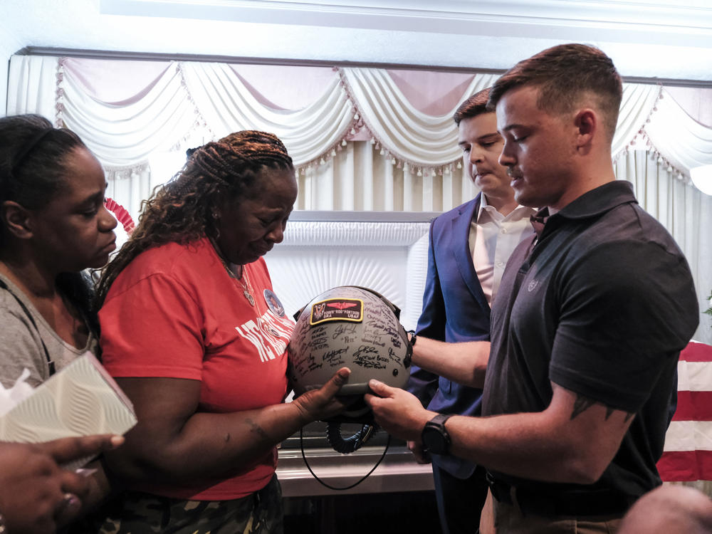 Members of the 73rd Special Operations Squadron presents Chantimekki Fortson, Roger Fortson's mother, a helmet in honor of her son in Atlanta on Thursday.