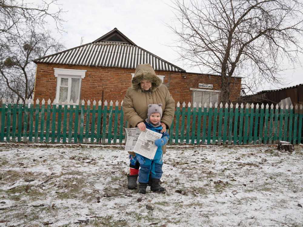 Olena Yeremenko stands with her grandson Nazar, 3, after picking up an edition of <em>Peremoha.</em>