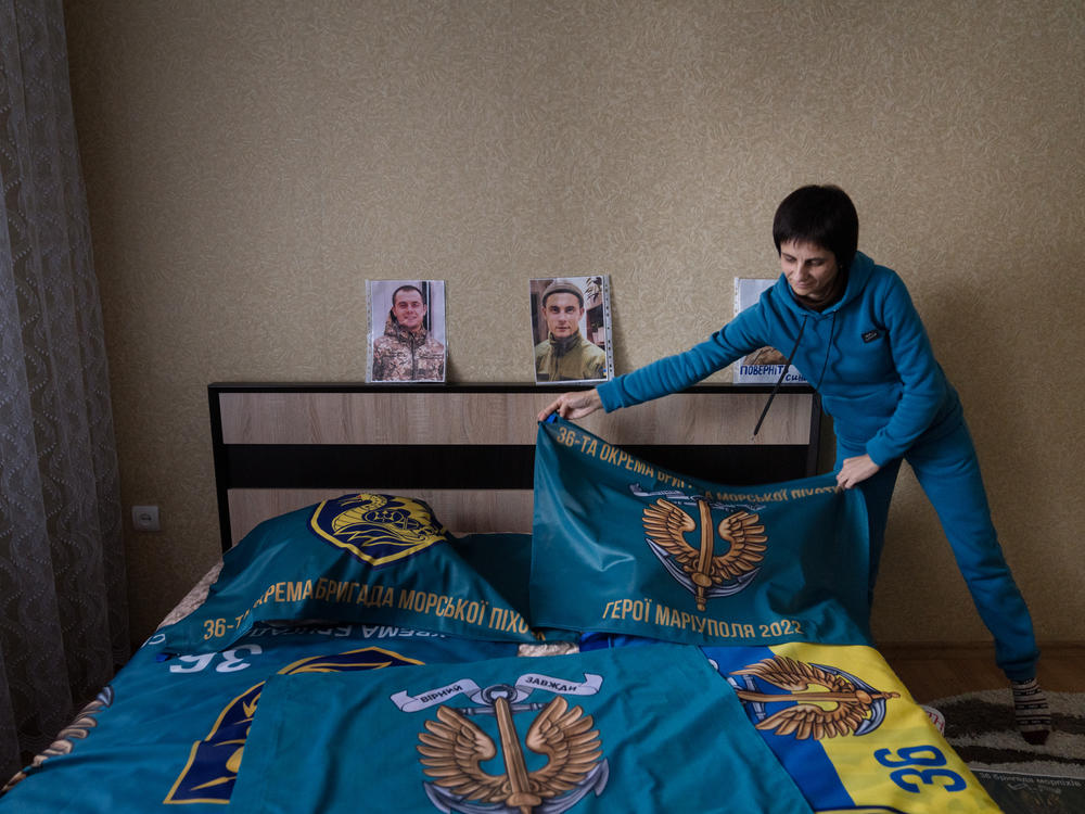 Nataliya Kucherenko adjusts a flag in her son's bedroom. Her son, Vova Kucherenko, is being held captive in Russia.