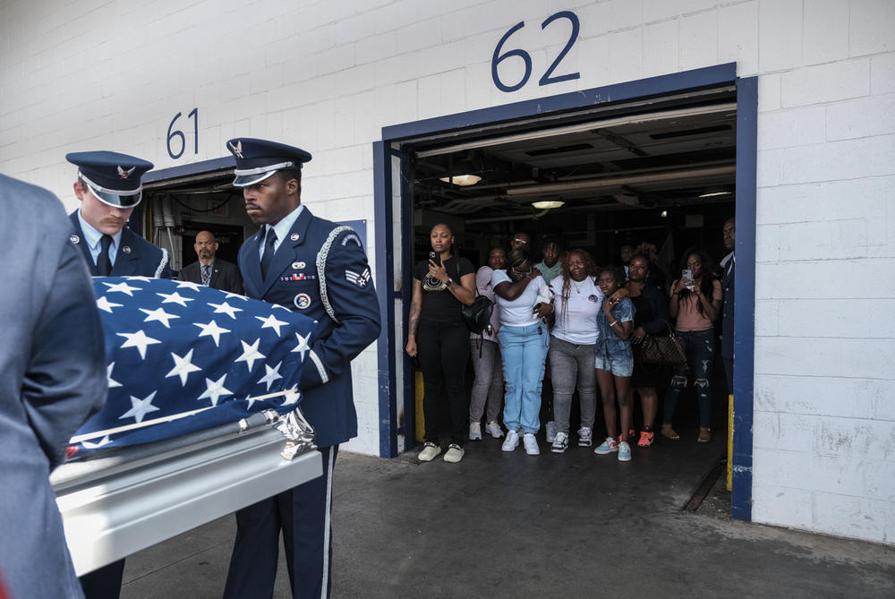 Chantimekki Fortson and daughter Harmoni Fortson watch as a U.S. Air Force Honor Guard loads the transfer case of Airman Roger Fortson into a hearse at the Hartsfield-Jackson Airport in Atlanta on Tuesday. Fortson was killed by a Florida sheriff's deputy on May 3 after answering his door while holding a gun.