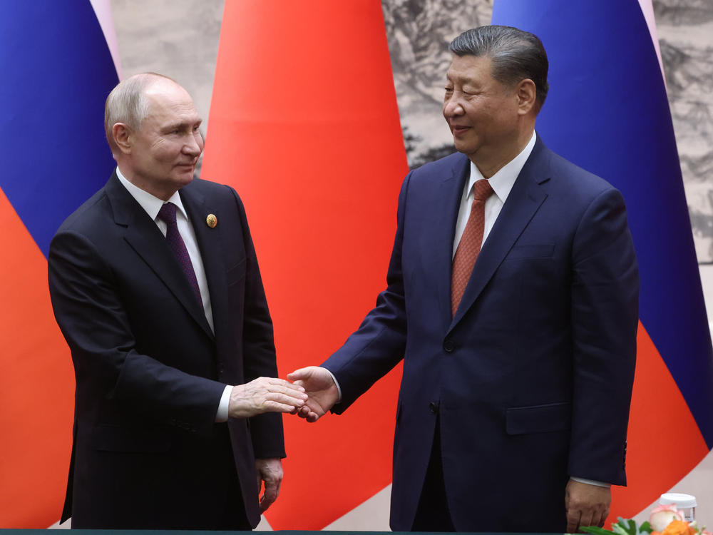 Russian President Vladimir Putin and Chinese President Xi Jinping shake hands during a bilateral meeting on Thursday in Beijing, China.