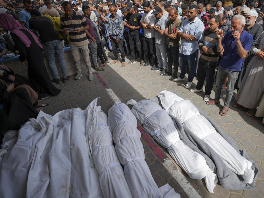 Mourners pray over the bodies of Palestinians who were killed in an Israeli airstrike in Nuseirat, at the Al Aqsa hospital in Deir al Balah, Gaza Strip, Sunday, May 19, 2024.