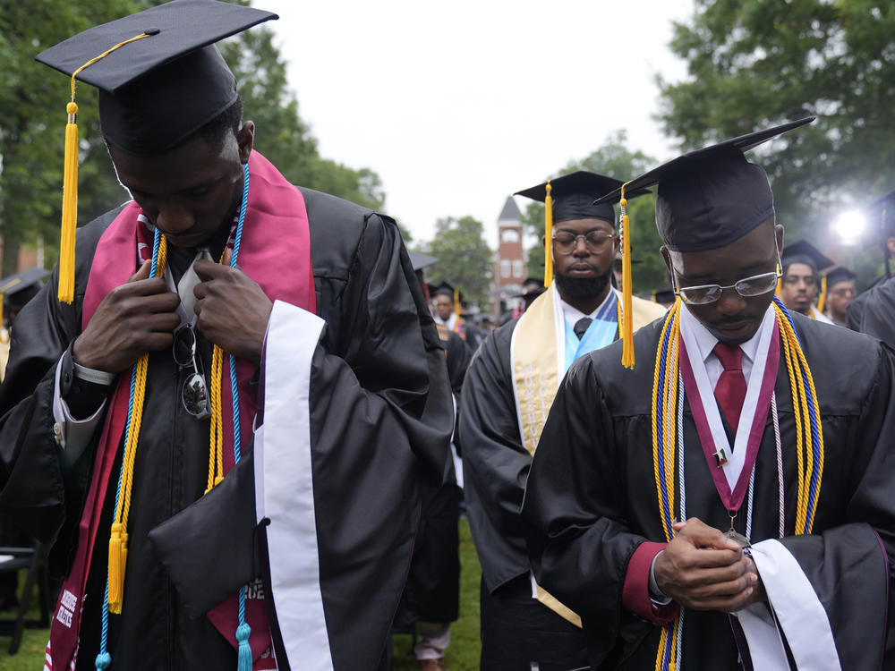 Graduating students at the Morehouse College commencement bow their heads Sunday in Atlanta. President Biden addressed the graduating class of 2024 and warned about 