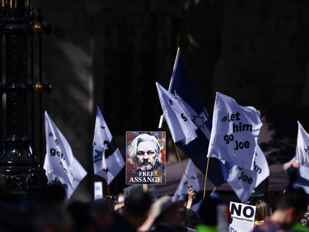 Supporters of WikiLeaks founder Julian Assange, fly a banner featuring an image of Assange, as they protest in support of him, outside The Royal Courts of Justice, Britain's High Court, in central London on Monday.