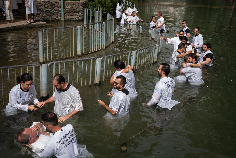 Evangelicals from Brazil wade, pray and get baptized in the Jordan river in Israel on May 11, 2024.