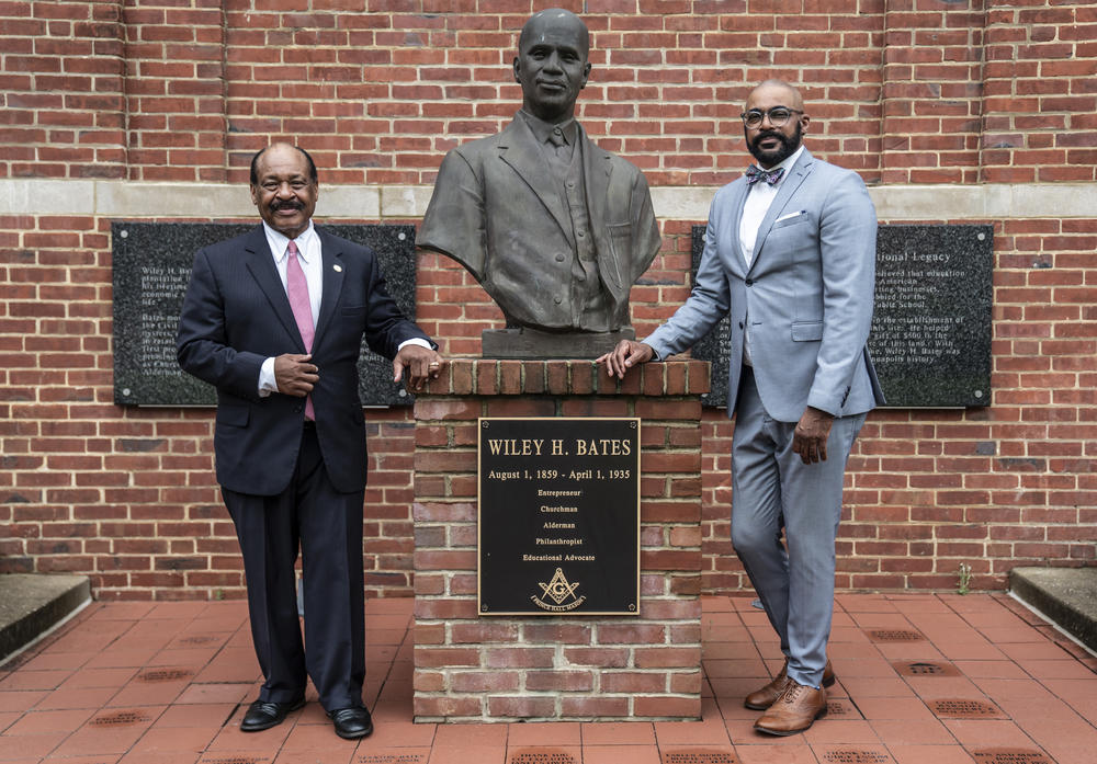 Carl Snowden (left) and attorney Daryl Jones (right), stand next to the Wiley H. Bates bust. Bates was born an enslaved man and rose to become a businessman and civic leader in Annapolis, Md.