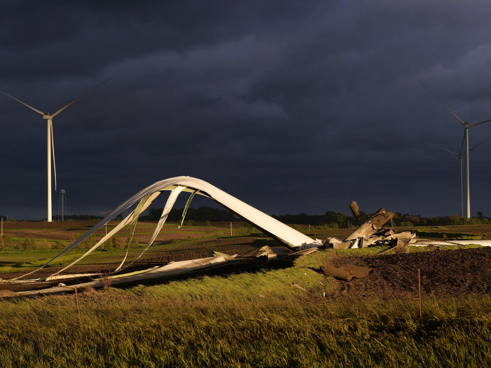 The remains of a tornado-damaged wind turbine touch the ground in a field Tuesday near Prescott, Iowa.