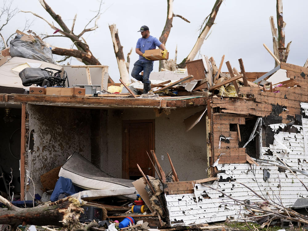 A man sorts through the remains of a home damaged by a tornado on Tuesday in Greenfield, Iowa.