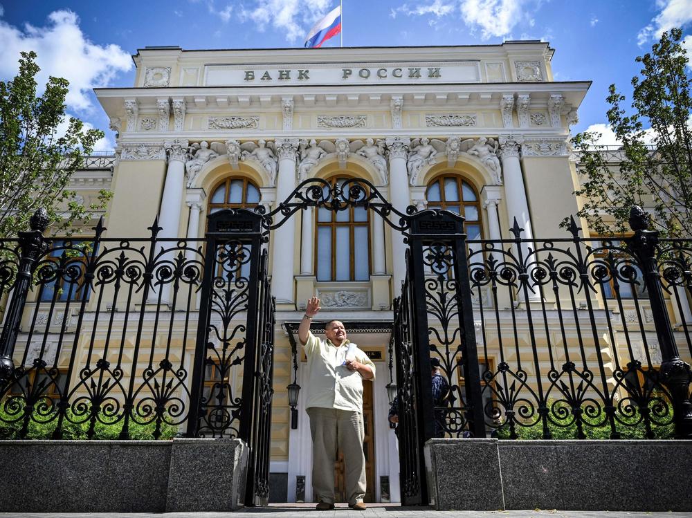 A man waves to a taxi as he leaves the Russian Central Bank headquarters in downtown Moscow last summer. The EU approved a plan this week to use interest from hundreds of billions of dollars' worth of seized Russian assets to help fund Ukraine's military.