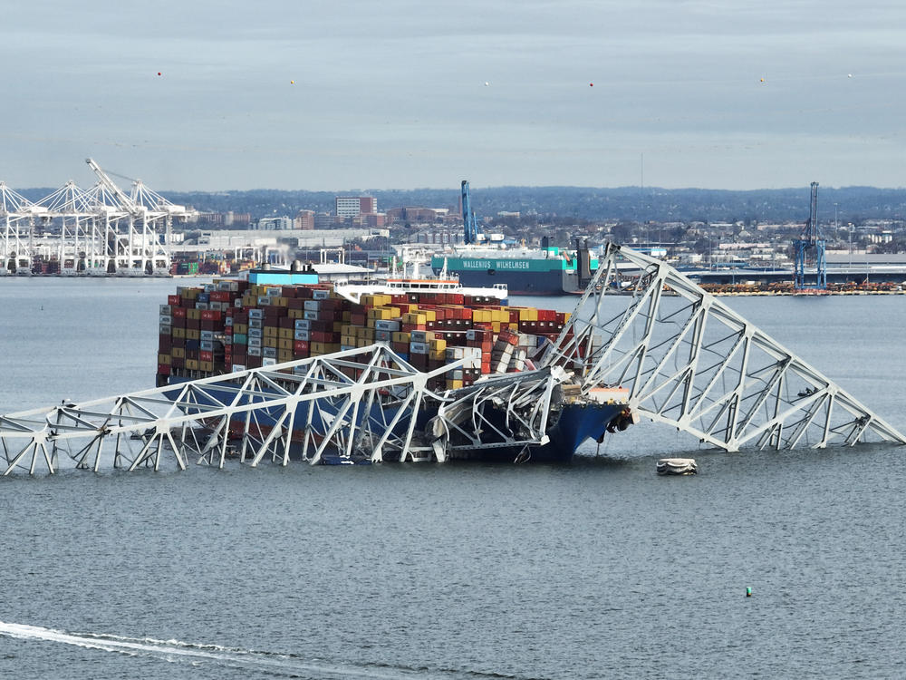 In this aerial image, the steel frame of the Francis Scott Key Bridge sits on top of a container ship after the bridge collapsed in Baltimore on March 26. It collapsed after being struck by the Singapore-flagged Dali container ship, sending multiple vehicles and people plunging into the frigid harbor below.