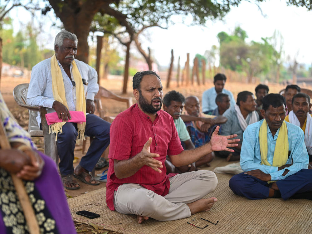 Alok Shukla (center) speaks with community members at the Morga village in India's state of Chhattisgarh. He partnered with local residents to stage protests to protect forests from coal mining interests — including a 10-day march.