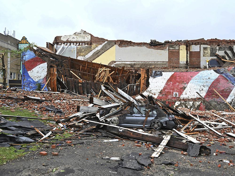 A car is crushed by a fallen building that hosted the Gansevoort mural that was struck by a tornado, in Rome, N.Y., on Tuesday. Much of the U.S. and Canada is cleaning up or still dealing with a new wave of severe storms that have caused deaths and damage this week from the Plains to New England.