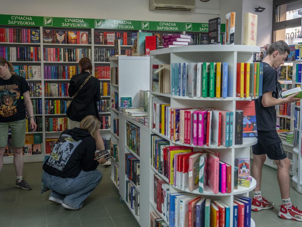 People peruse the bookshelves at the bookstore of Vivat, one of Ukraine's largest publishing houses, on May 26. A printing house used by Vivat was hit by a Russian strike a few days prior, killing seven workers.