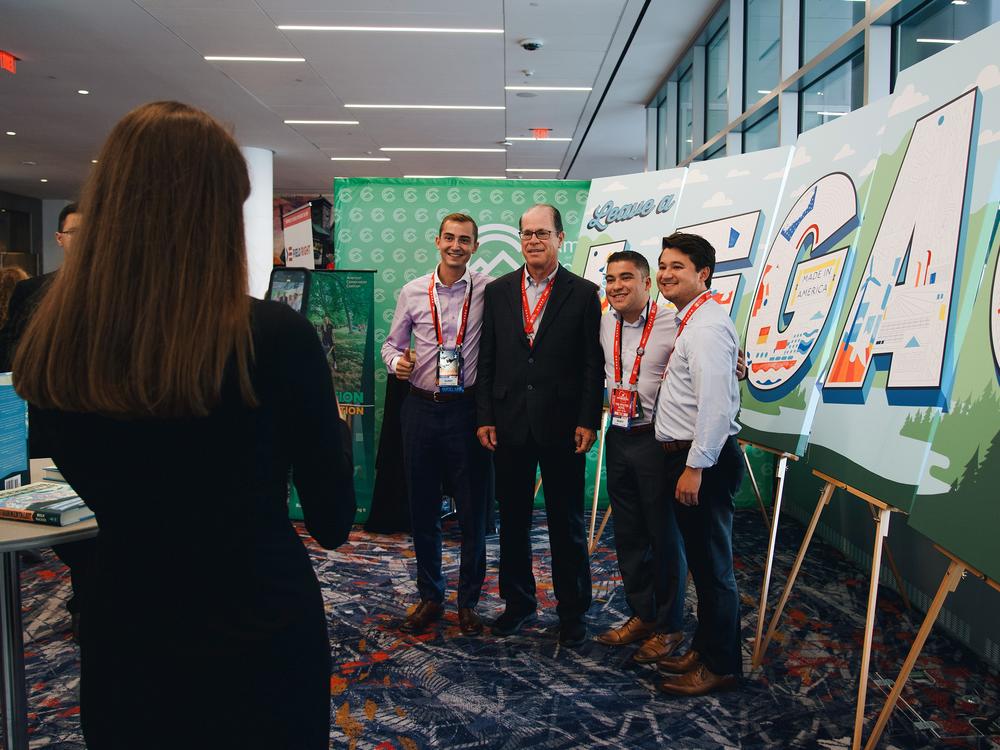 Aidan Shank, Brian Martinez and Michael Esposito take a photo with Republican Senator of Indiana, Mike Braun, at ACC's booth in Baird Center during the second day of the Republican National Convention.