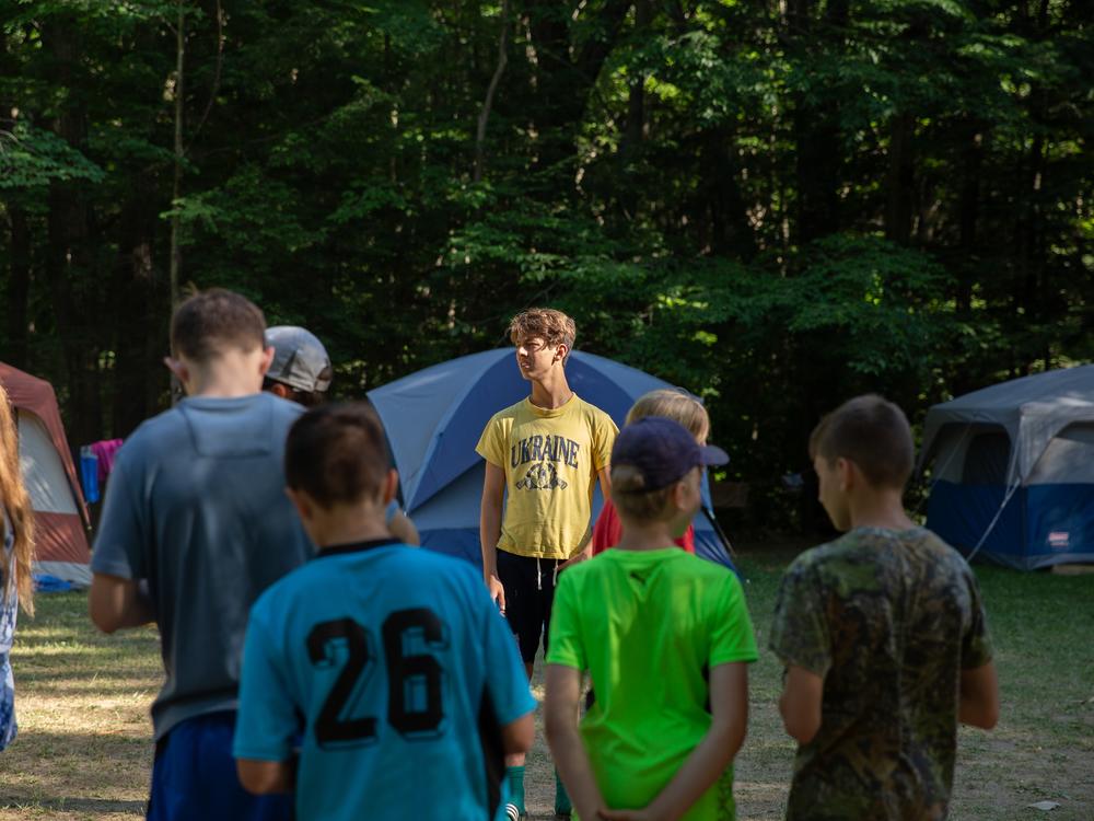 A <em>druh</em>, or male counselor to the older campers, calls his campers over to line up for the next activity.