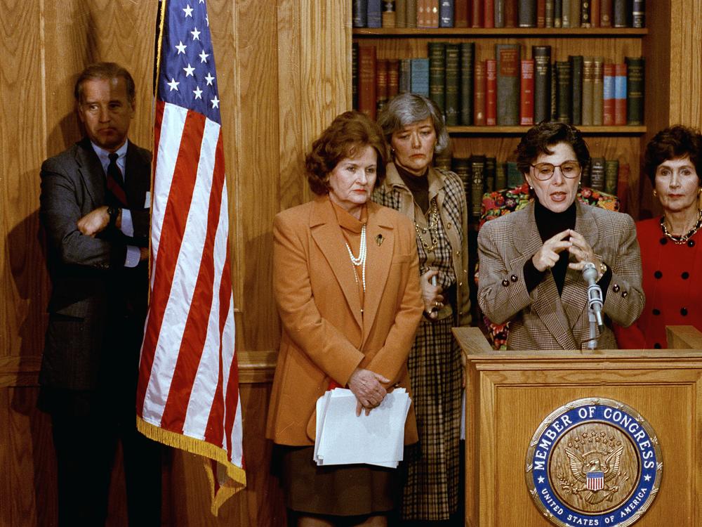 Then-Sen. Joe Biden, D-Del., stands behind a flag as Sen. Barbara Boxer, D-Calif., discusses the Violence Against Women Act on Capitol Hill on Feb. 24, 1993.
