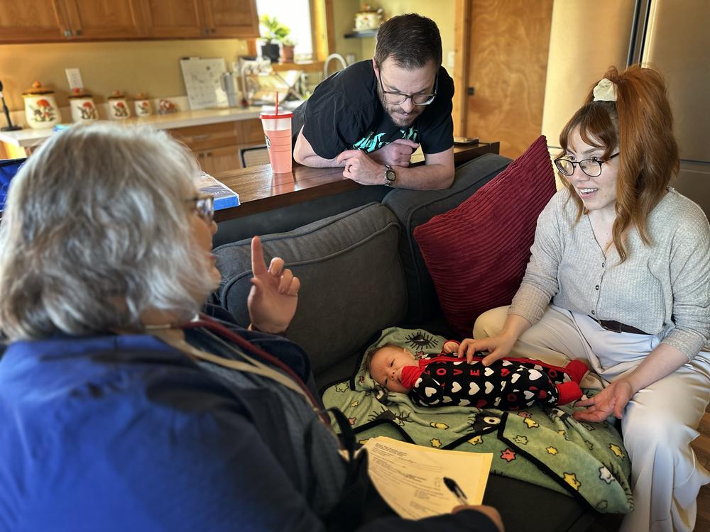 Barb Ibrahim, left, drove half an hour to visit Amber and Matt Luman and their new daughter, Esserley. Ibrahim, a nurse of more than 30 years, is part of new program in Oregon that offers free home visits from a registered nurse for any family with a newborn.