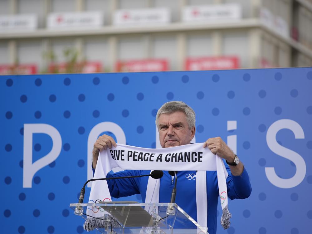IOC President Thomas Bach holds a scarf during the inauguration of the Olympic Truce Wall in the Olympic Village at the 2024 Summer Olympics on Monday in Paris, France.