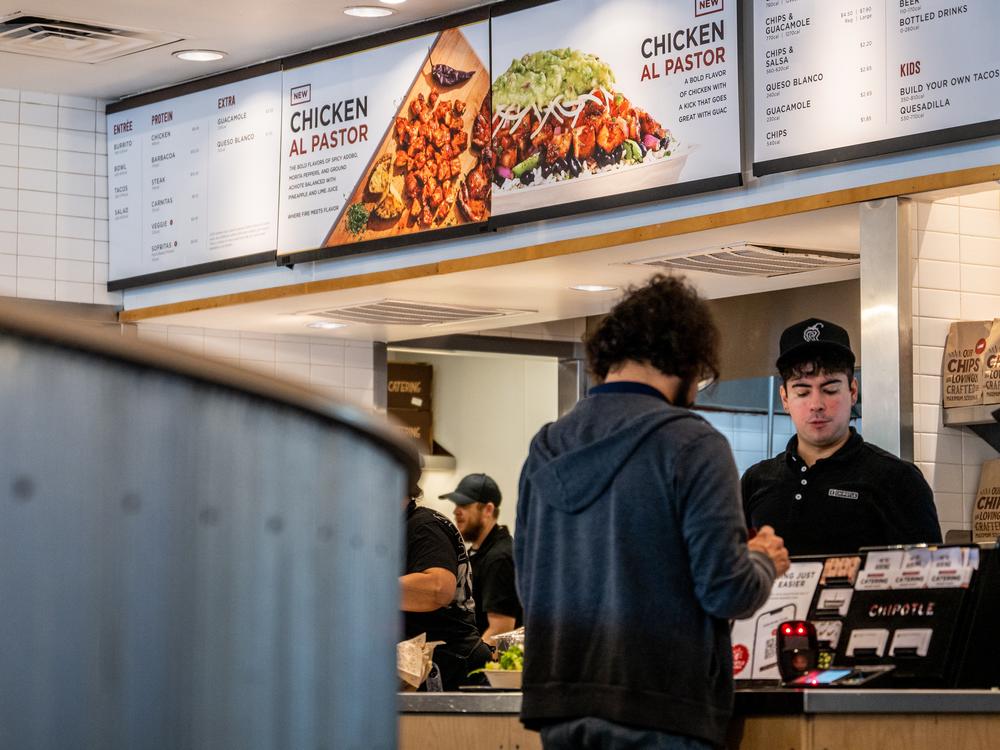 A customer pays for their food at a Chipotle Mexican Grill restaurant in Austin, Texas. Chipotle says its portion sizes have not shrunk, despite complaints shared on social media. 