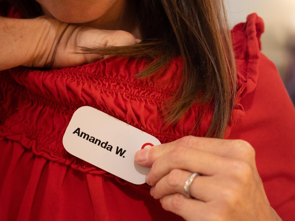 Amanda Whitworth of Panama City Beach, Fla., puts on her name badge for her job at Target on July 18.