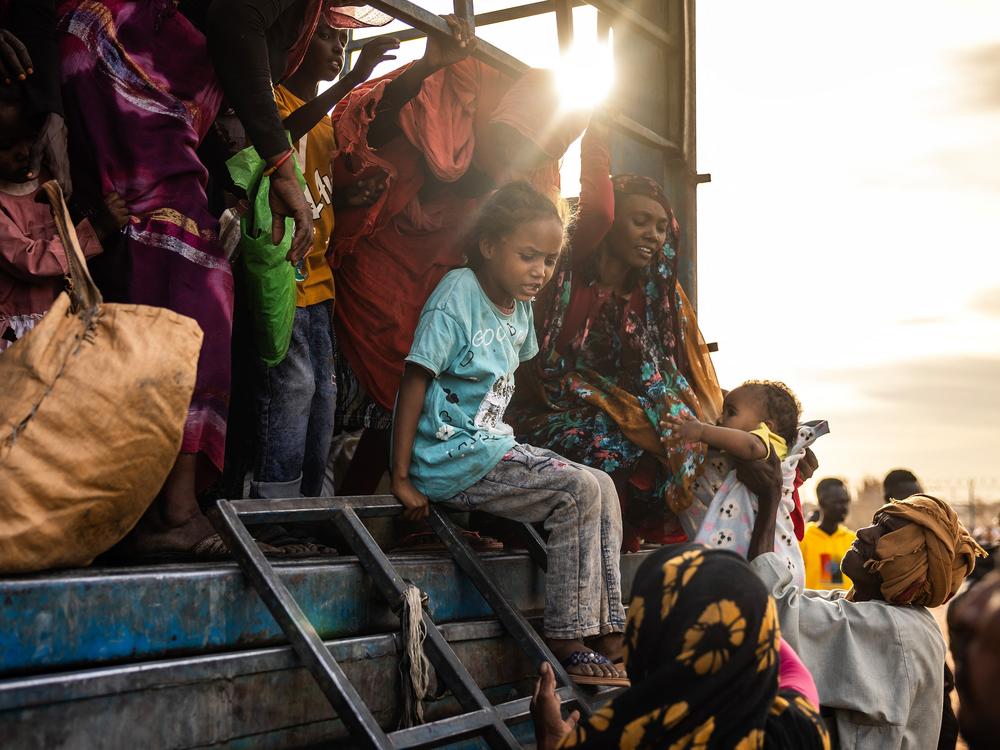 A Sudanese girl who has fled from the war with her family arrives at a refugee transit center. The conflict that began in April 2023 has displaced millions and created a humanitarian crisis.