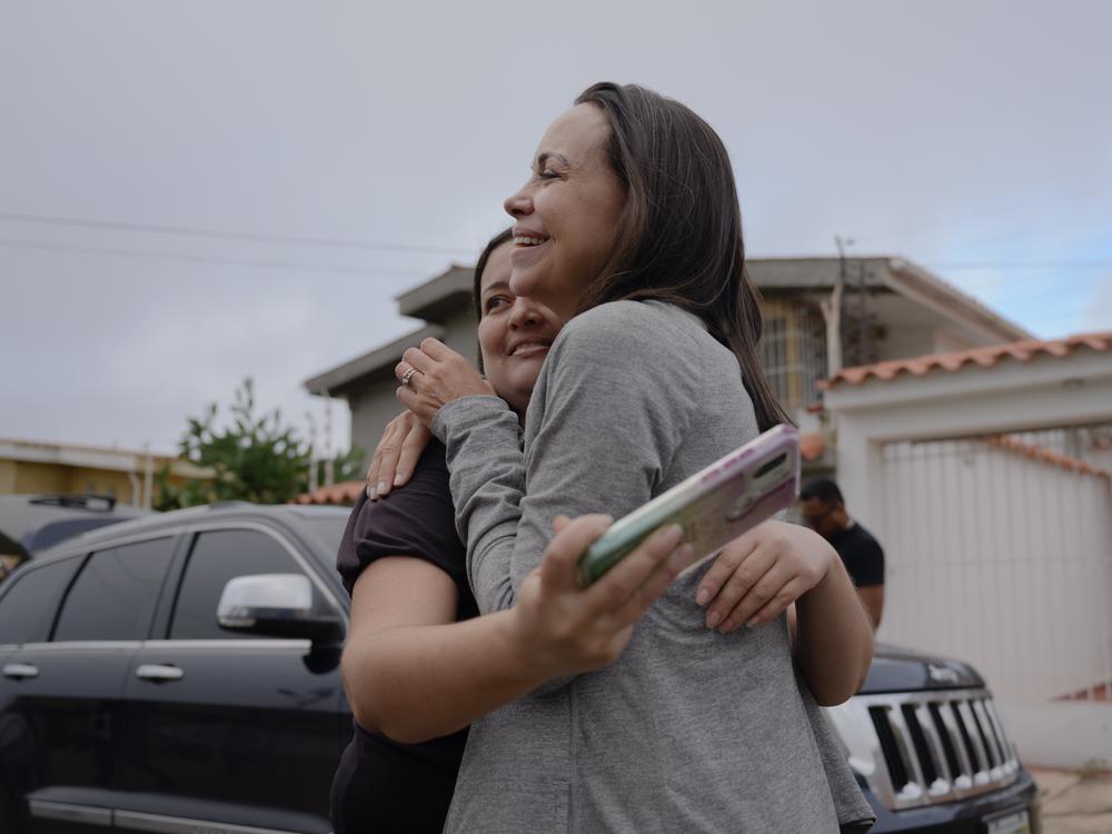 Venezuelan opposition leader María Corina Machado (right) makes a stop in a neighborhood in the city Barquisimeto on her way to Maracaibo, Venezuela's second-largest city, for a political rally in support of opposition candidate Edmundo González Tuesday morning. While her team refuels their vehicles, residents come out for the chance to meet Machado in person days before the election.