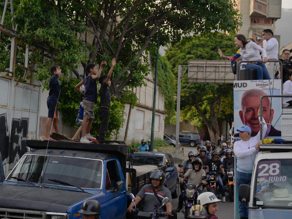 People attend the closing campaign event of opposition candidate Edmundo González, with party leader María Corina Machado, in Las Mercedes, a neighborhood of Caracas, on Thursday. While the streets were not officially closed off, people filled the streets and stopped traffic to support the pair.