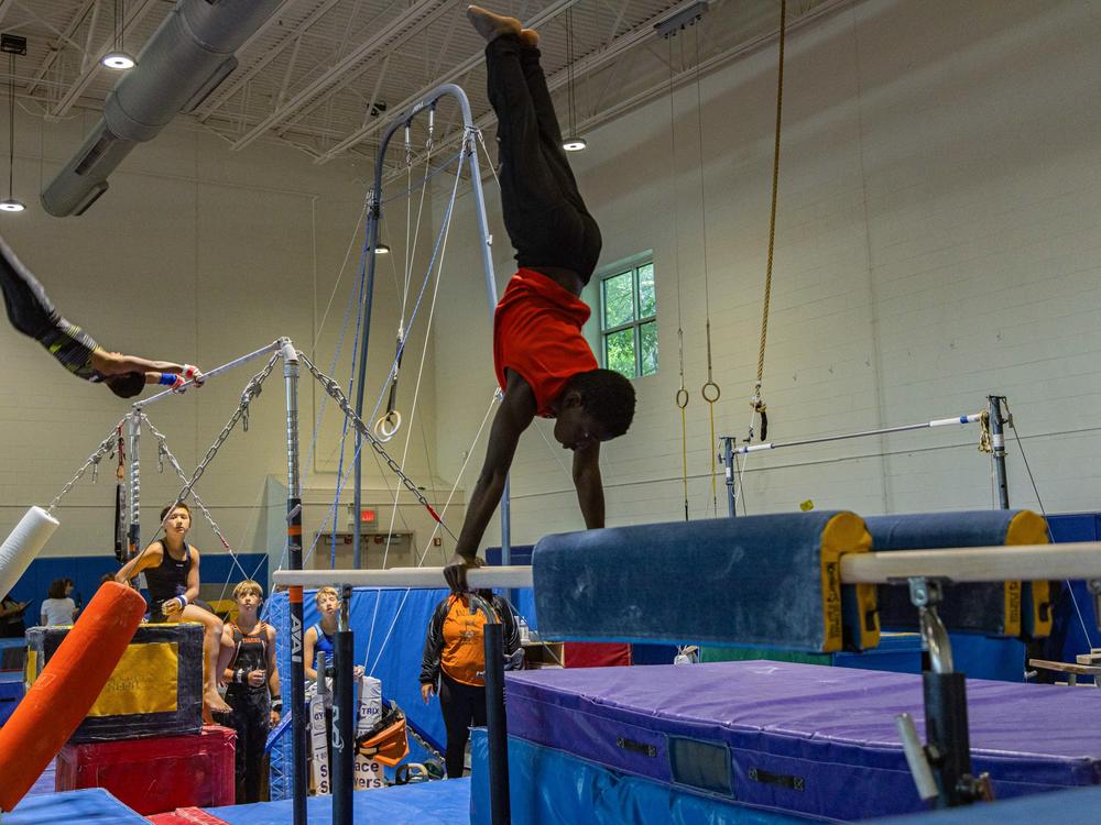 Practice sessions in the sport tend to be long, with many skills to perfect. Here, boys on the Arlington Tigers practice on the high bar and parallel bars.