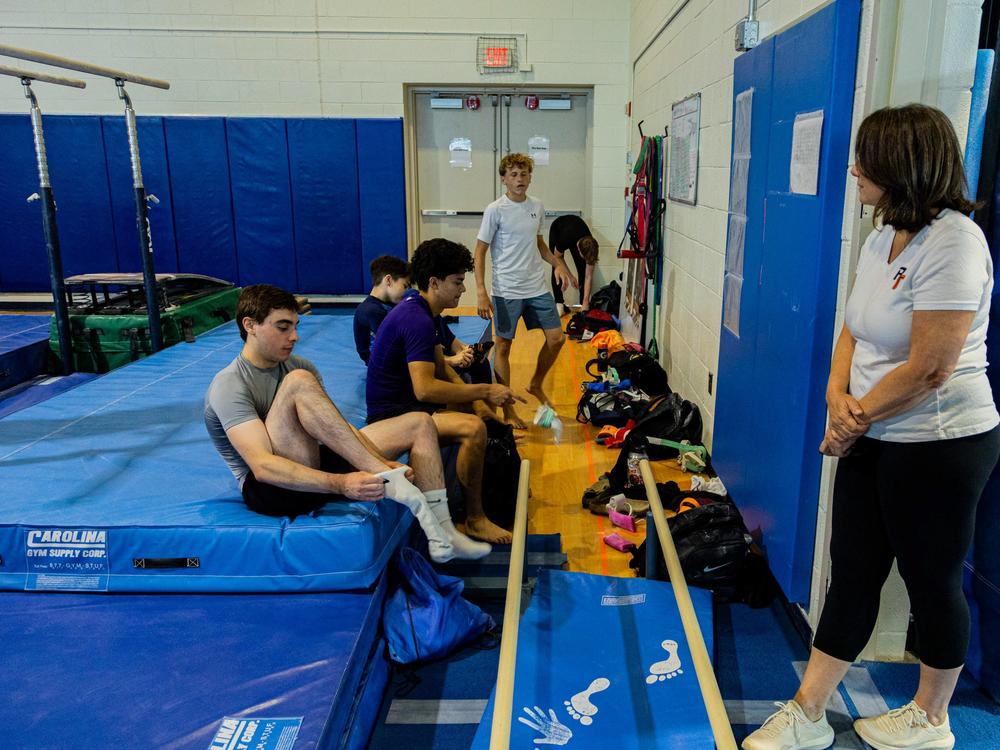Evan Virtue (left) and his teammates on the Arlington Tigers prepare to train on their next event, facing Sonja Hird Clark, who founded the boys team.