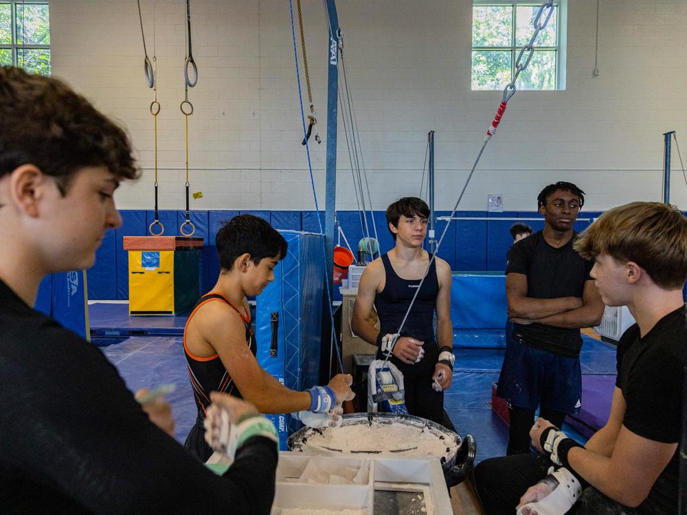 Gymnasts on the Arlington Tigers chalk up their hands at practice on July 2 in Arlington, Va.
