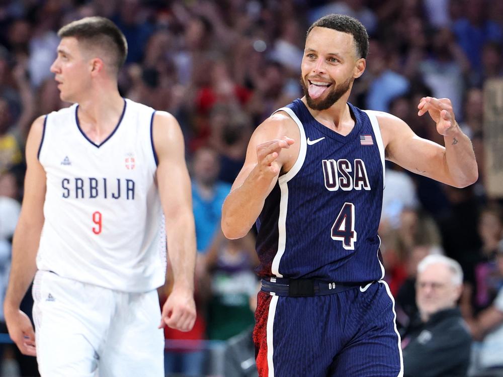 Stephen Curry reacts at the end of the USA game against Serbia. It's his first Olympics and he says he's trying to savor every minute of it.
