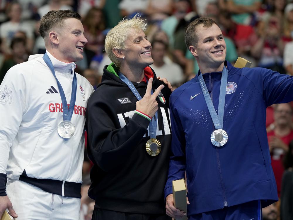 Adam Peaty, left, of Great Britain, tested positive for COVID on Monday, a day after he stood with Gold medalist Nicolo Martinenghi, center, of Italy, and dual silver medalist Nic Fink, of the United States. The men competed in the 100-meter breaststroke final at the 2024 Paris Olympics in Nanterre, France.