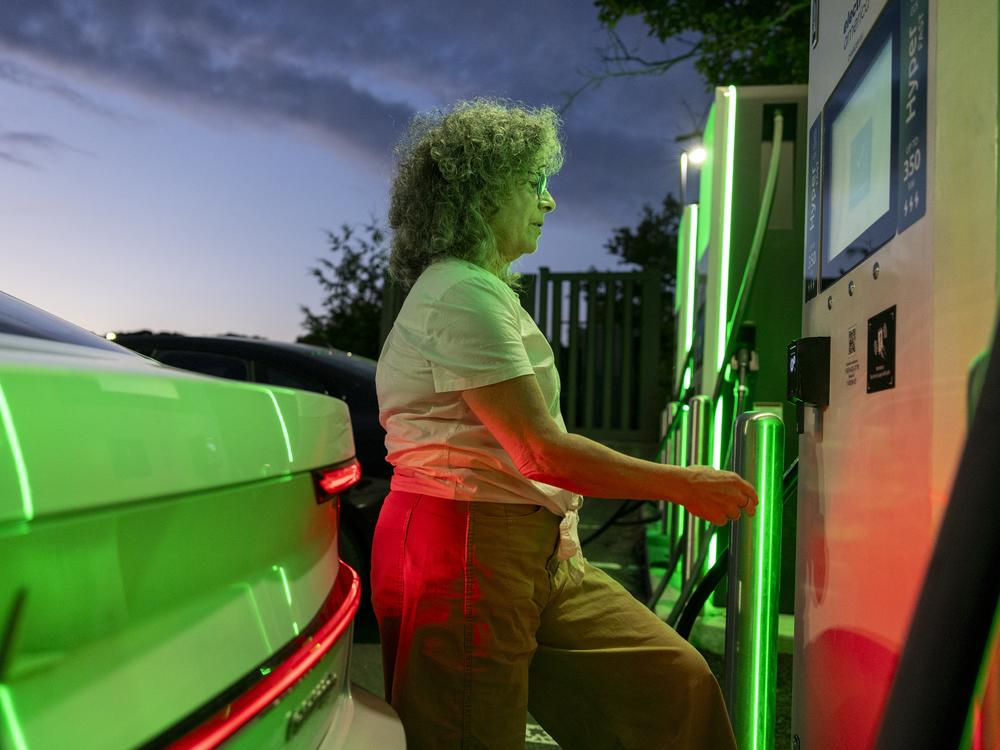 Beth Shapiro pays to charge her electric vehicle in Connecticut.