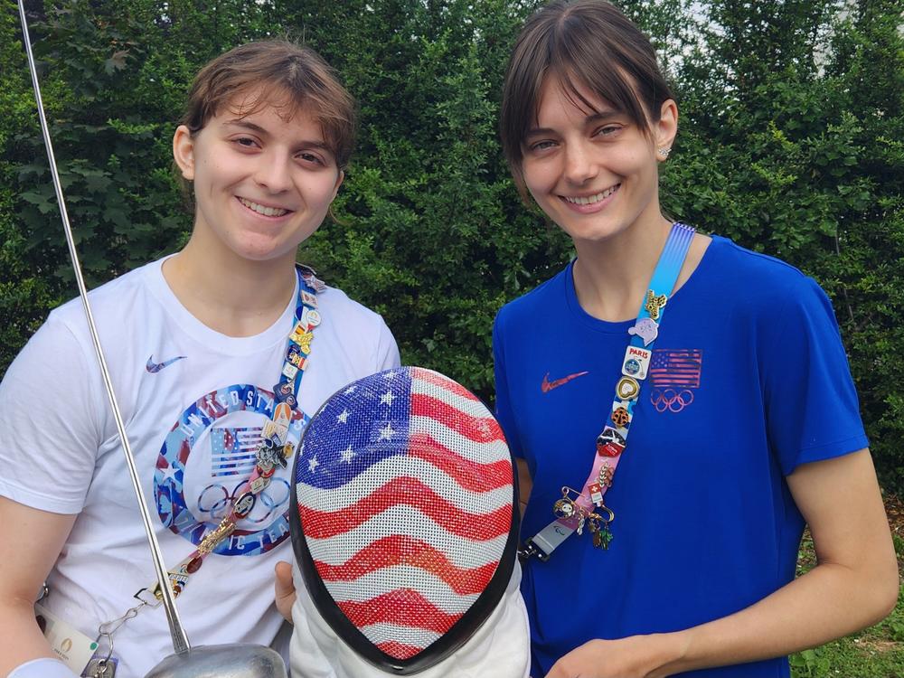 Hadley Husisian (L) and Anne Cebula fence with a type of sword called an epee, a long needle of steel tipped with a button that registers points or 