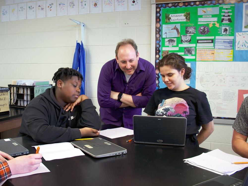 Ben Kravitz, an assistant professor of earth and atmospheric sciences at Indiana University, chats with high school students DeWayne Murphy and Emerald Yee during a class at Bloomington High School South.