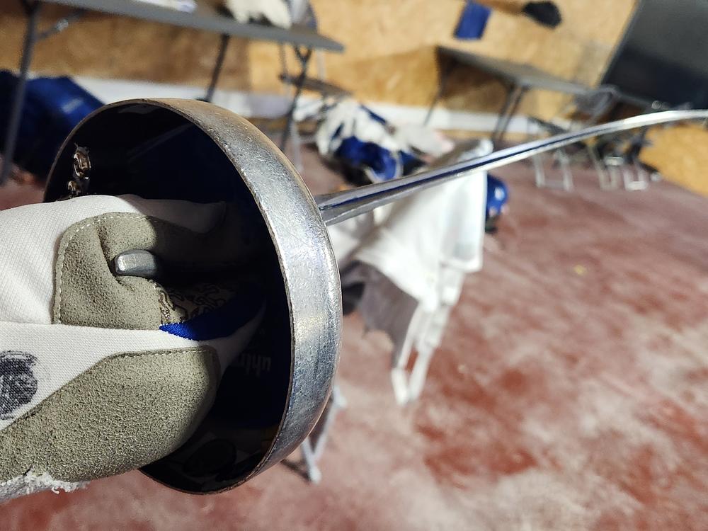 Hadley Husisian grips her epee, which is tipped with a button that marks points or 