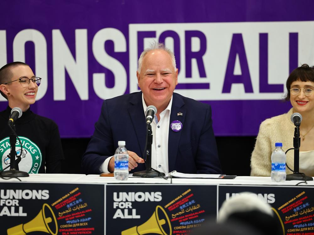 Minnesota Gov. Tim Walz speaks with union organizers before they march on businesses in downtown Minneapolis on Oct. 14, 2022.