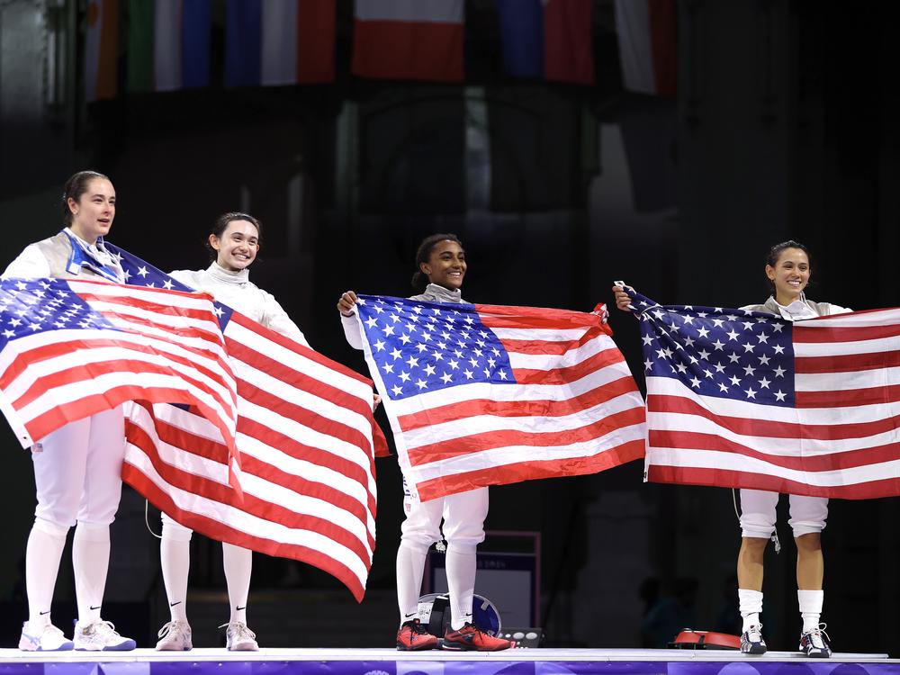 Jacqueline Dubrovich, Maia Weintraub, Lauren Scruggs and Lee Kiefer celebrate winning against Team Italy during the fencing women's foil team gold medal match at the Grand Palais in Paris.