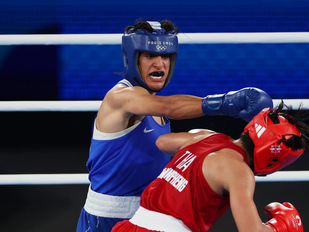 Imane Khelif of Algeria (blue) punches Janjaem Suwannapheng of Thailand during the Women's 66kg semifinal bout on Tuesday at the Paris Olympic Games.