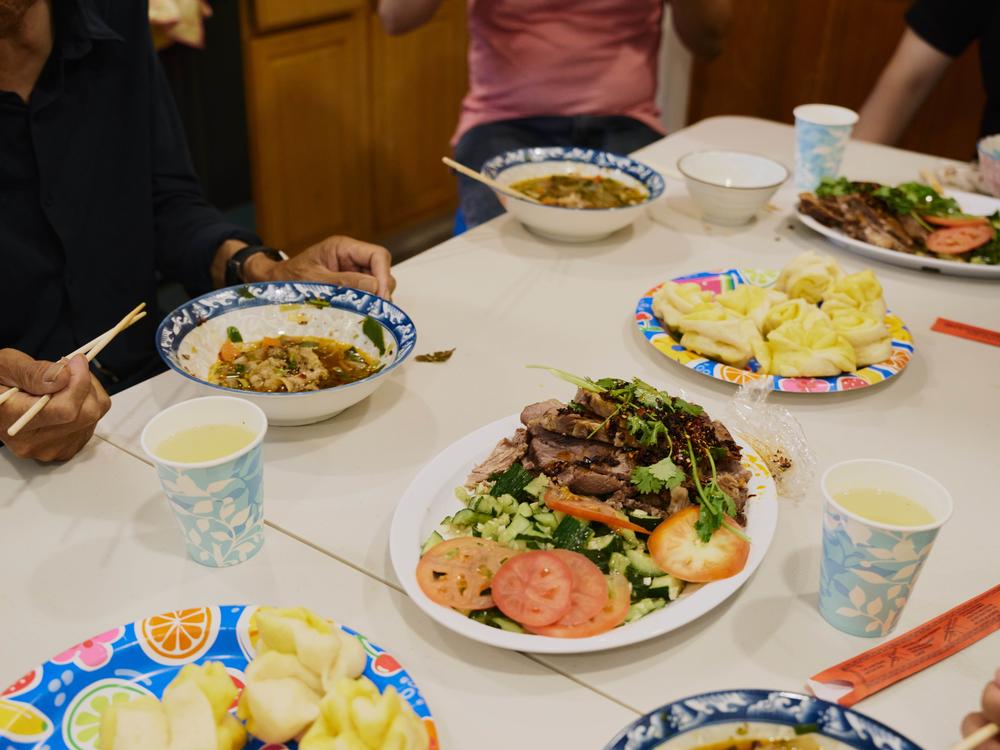 Migrants share a homemade communal meal at a group home in Queens, N.Y.