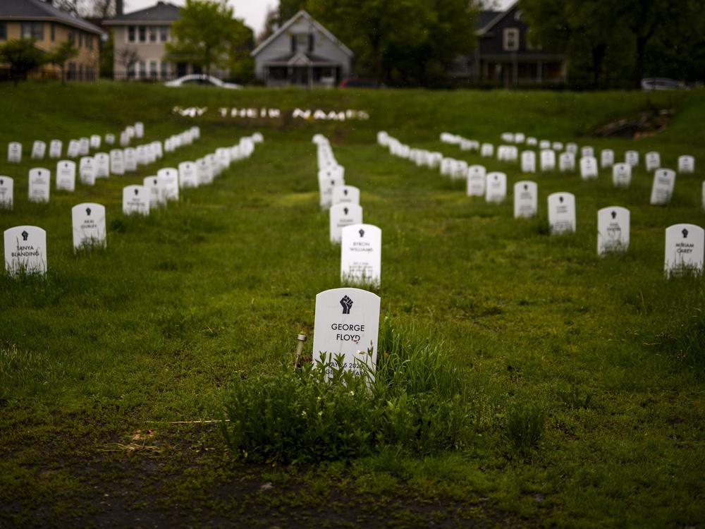 A memorial made to look like a cemetery stands in a grassy field near the intersection where George Floyd was killed in Minneapolis, Minn.