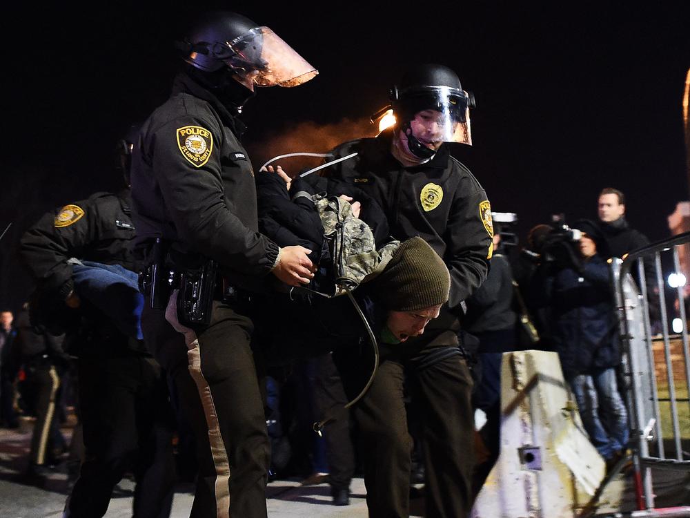 Police arrest a protester in Ferguson, Missouri, on November 25, 2014 during demonstrations a day after violent protests and looting following the grand jury decision in the fatal shooting of a 18-year-old black teenager Michael Brown. 