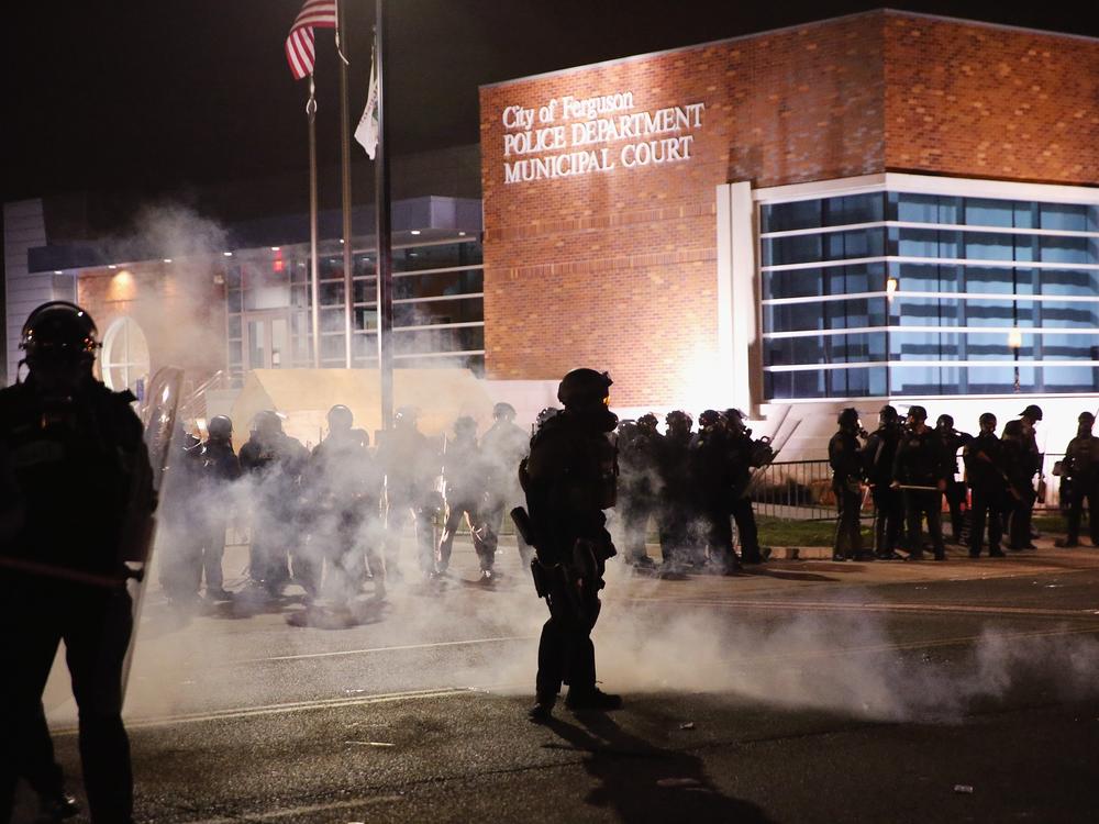 Police guard the Ferguson police department as rioting erupts following the grand jury announcement in the Michael Brown case on November 24, 2014 in Ferguson, Missouri. 