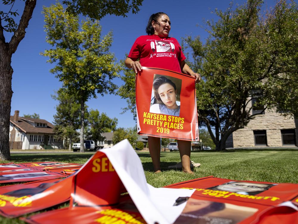 Melissa Lonebear holds a banner with a picture of Kaysera Stops Pretty Places on it during a rally in support of the Missing and Murdered Indigenous People movement at the Big Horn County Building in Hardin, Mont., on Aug. 29, 2023.