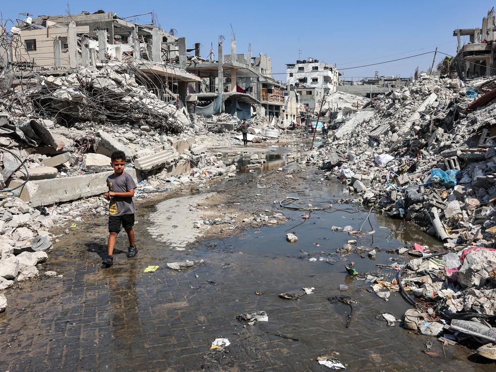 A boy walks through a puddle of sewage water past mounds of trash and rubble along a street in the Jabalia camp for Palestinian refugees, in the northern Gaza Strip, on Wednesday.